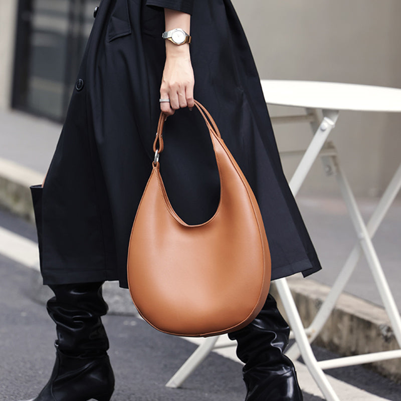 Woman carrying large crescent hobo bag on shoulder – ARLANA