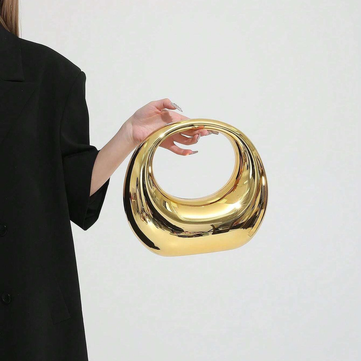 Woman holding gold ring handle clutch bag – ARLANA