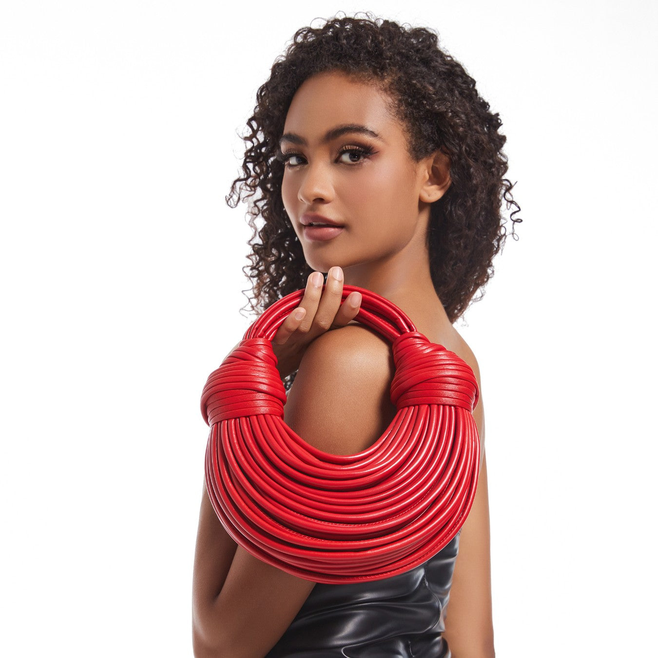 Woman carrying sculptural red hoop handbag – ARLANA