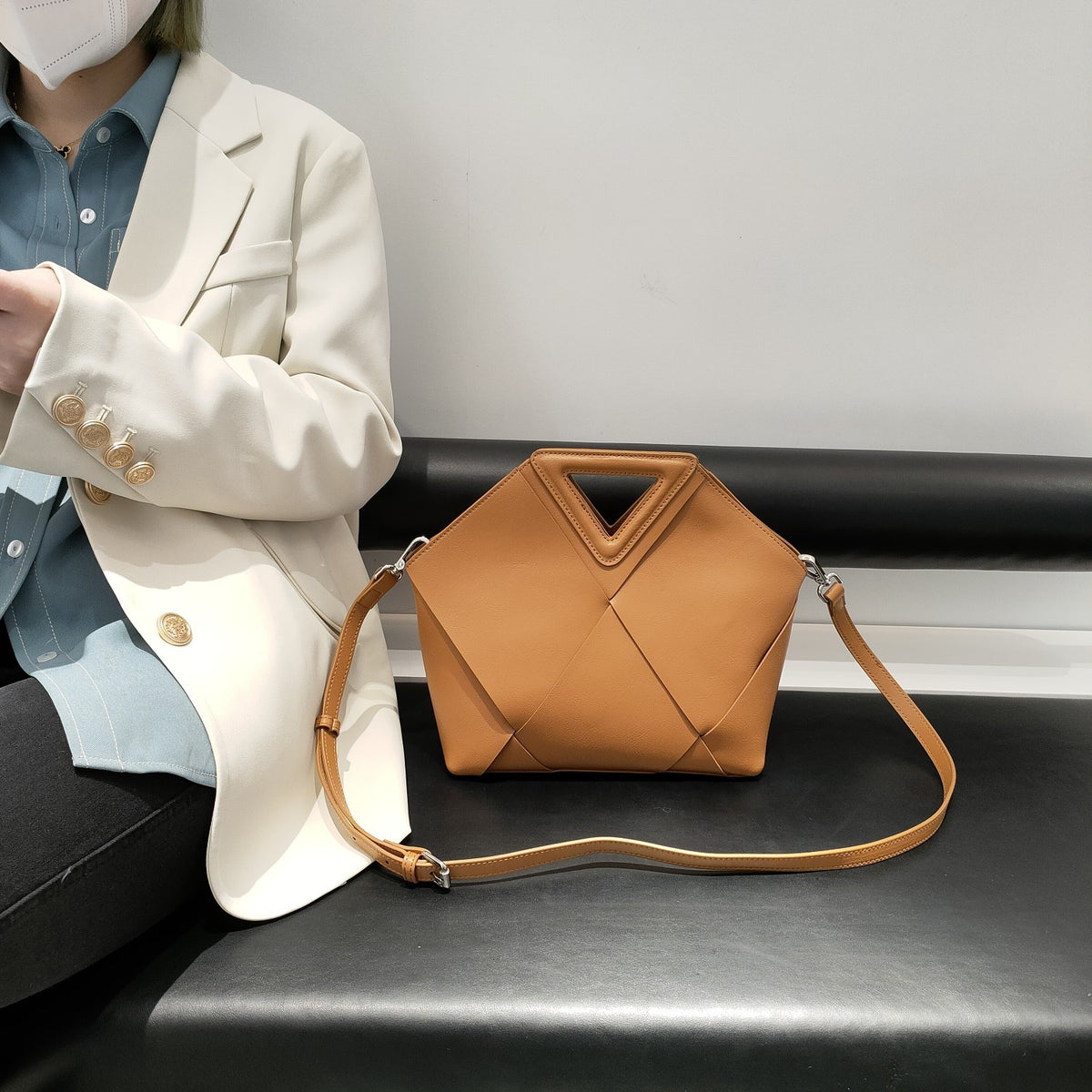 Model carrying angular vegan leather shoulder bag in Brown – ARLANA